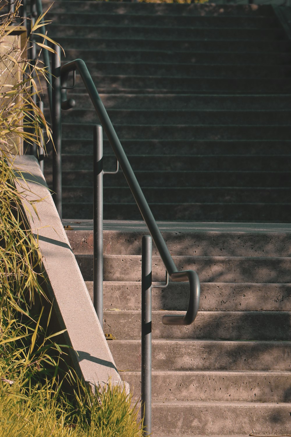 a metal hand rail next to a set of stairs