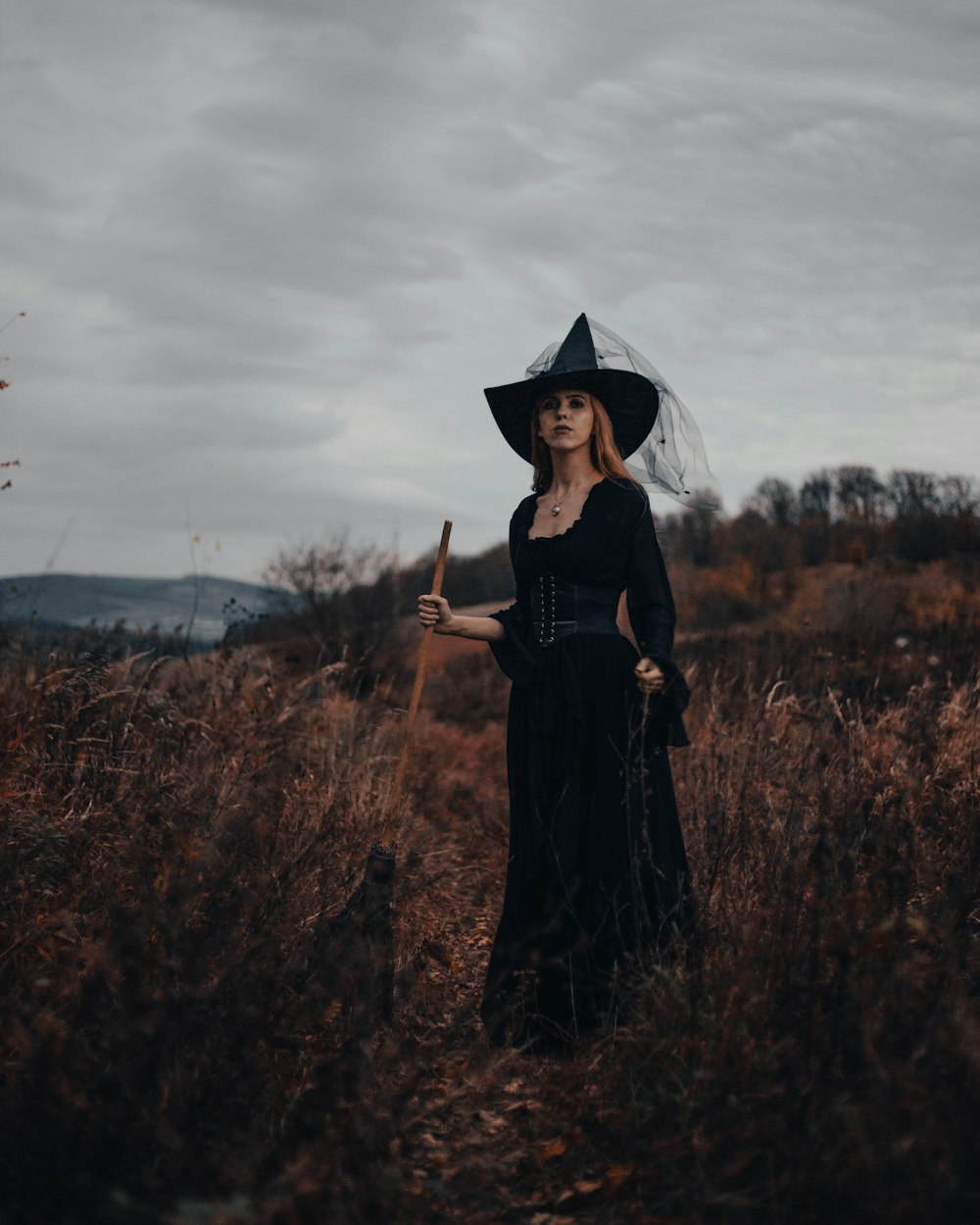 Eine Frau trägt ein schwarzes Kleid und einen schwarzen Hut