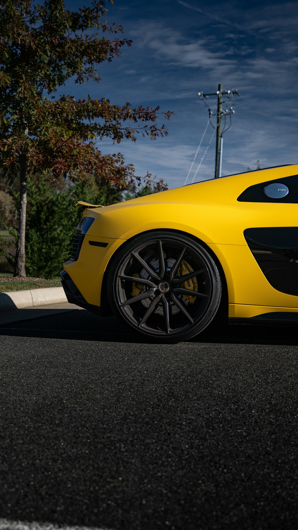 a yellow sports car parked on the side of the road