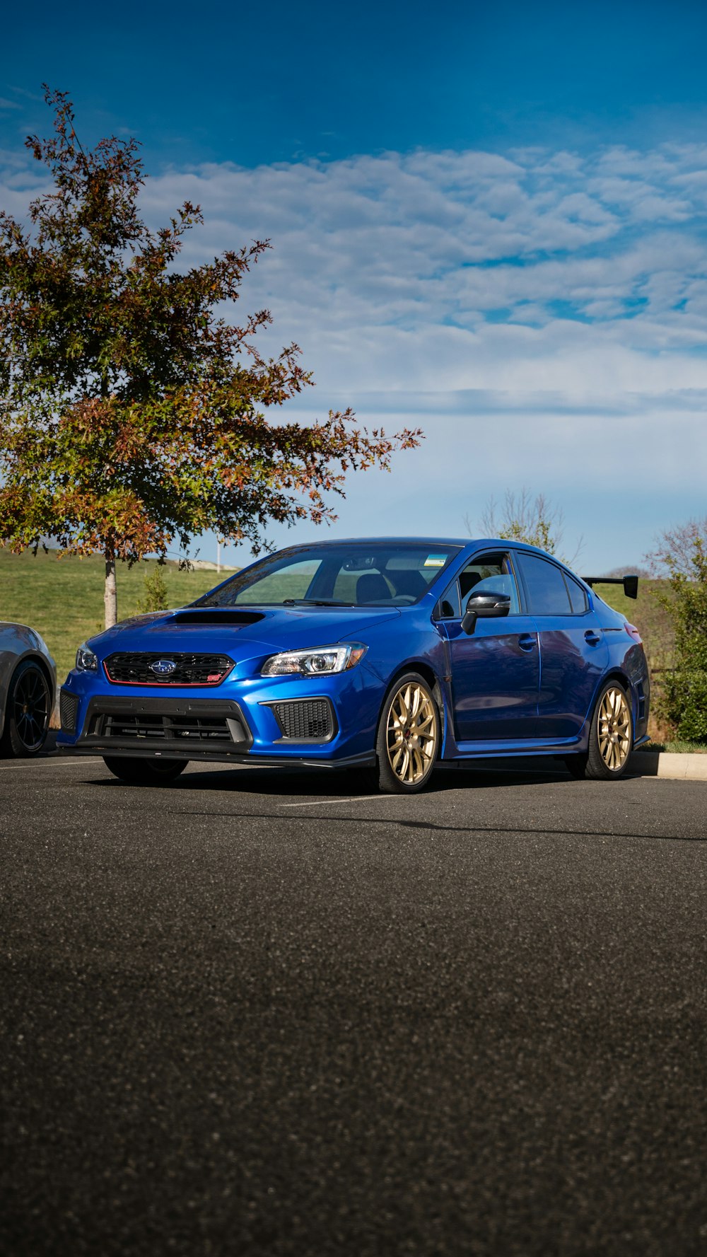 a blue subarunt parked next to a black car