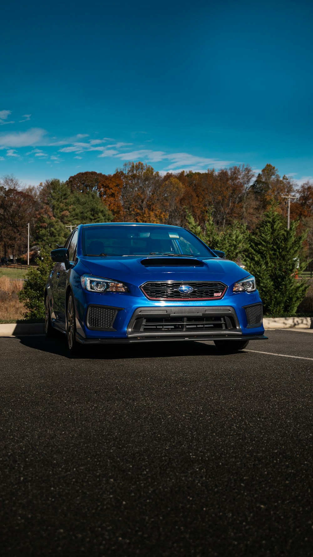 a blue subarunt is parked in a parking lot