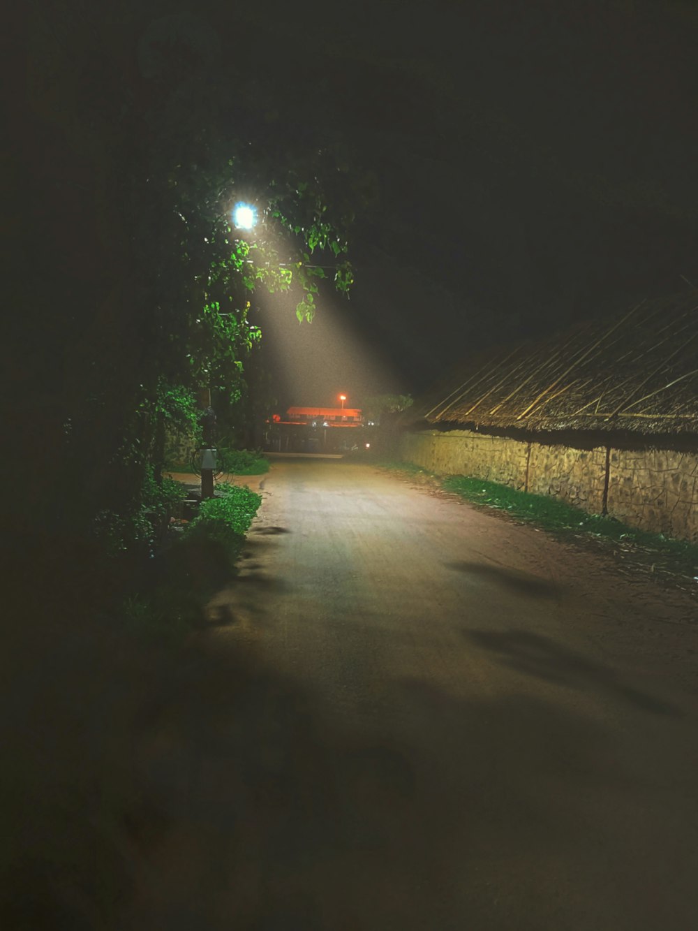 a street light shines brightly on a dark street