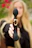 Smiling woman holding a sleek security device from Voltaris outdoors.