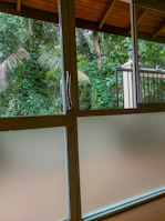 Sturdy glass sliding door opening to a vibrant outdoor patio space.