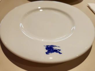 A detailed shot of a porcelain plate featuring subtle brush strokes and a glossy finish
