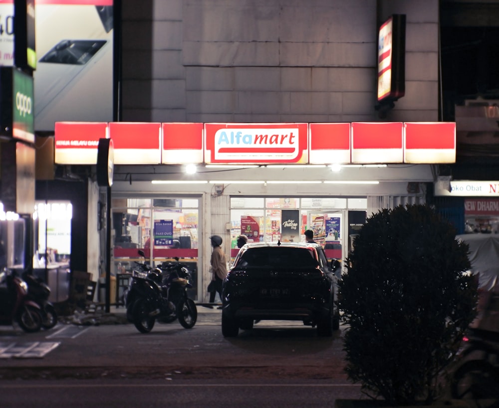 Un coche aparcado frente a una tienda por la noche