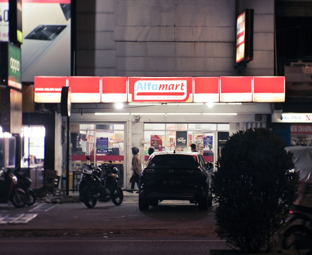 um carro estacionado em frente a uma loja à noite