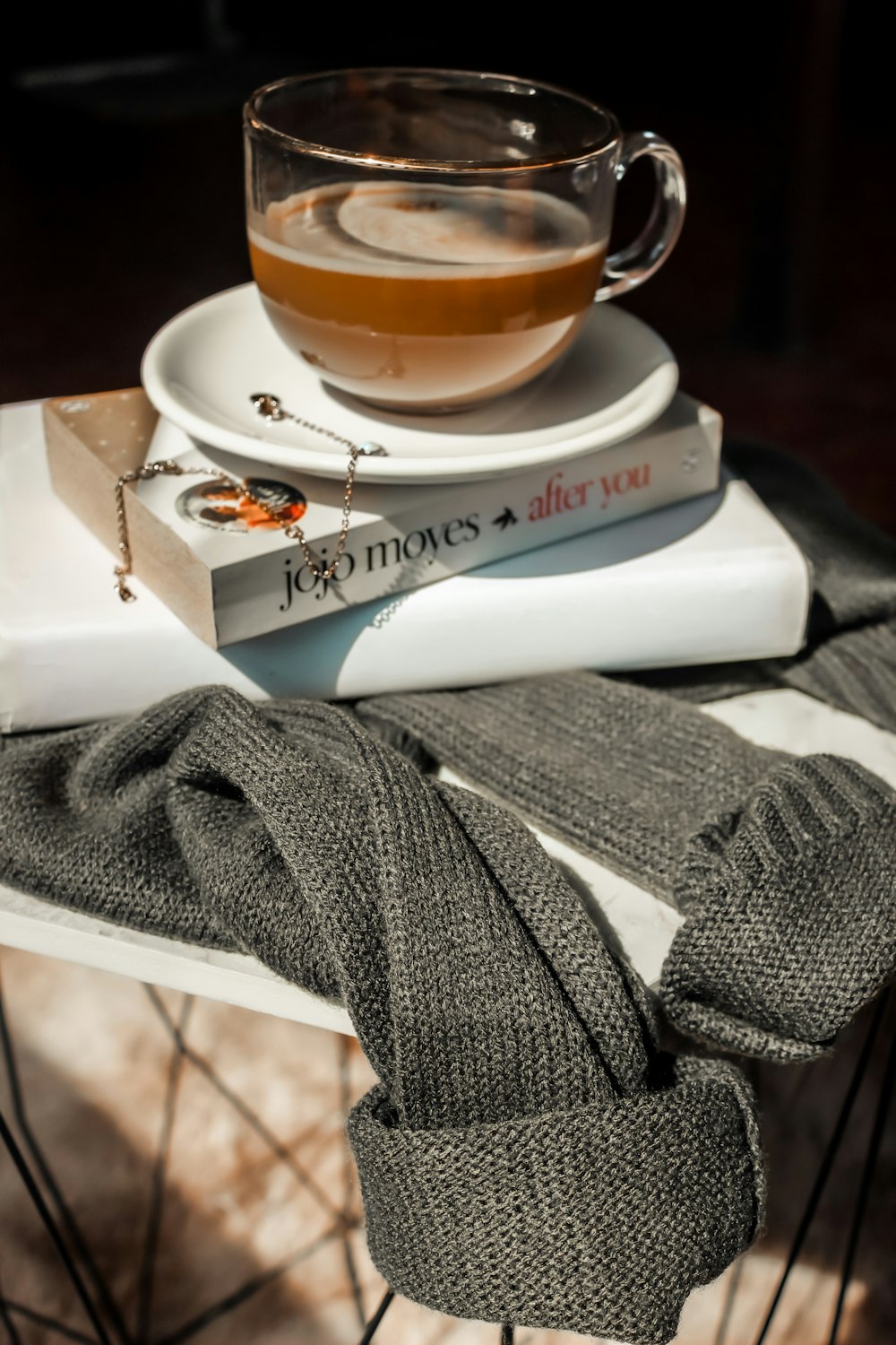 a stack of books sitting on top of a table next to a cup of tea