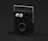 A sleek, modern black speaker with a rectangular shape and a silver handle on top. The speaker features two large knobs and a small port on the front panel, along with a circular speaker at the bottom section. The design is minimalistic and utilitarian.