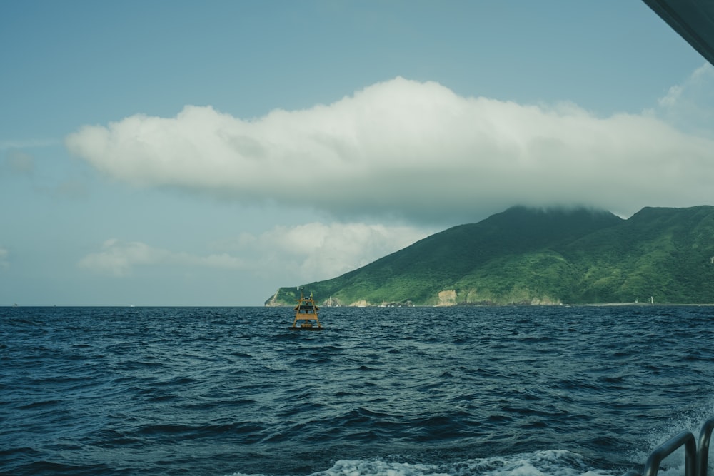 a boat in the ocean with a mountain in the background