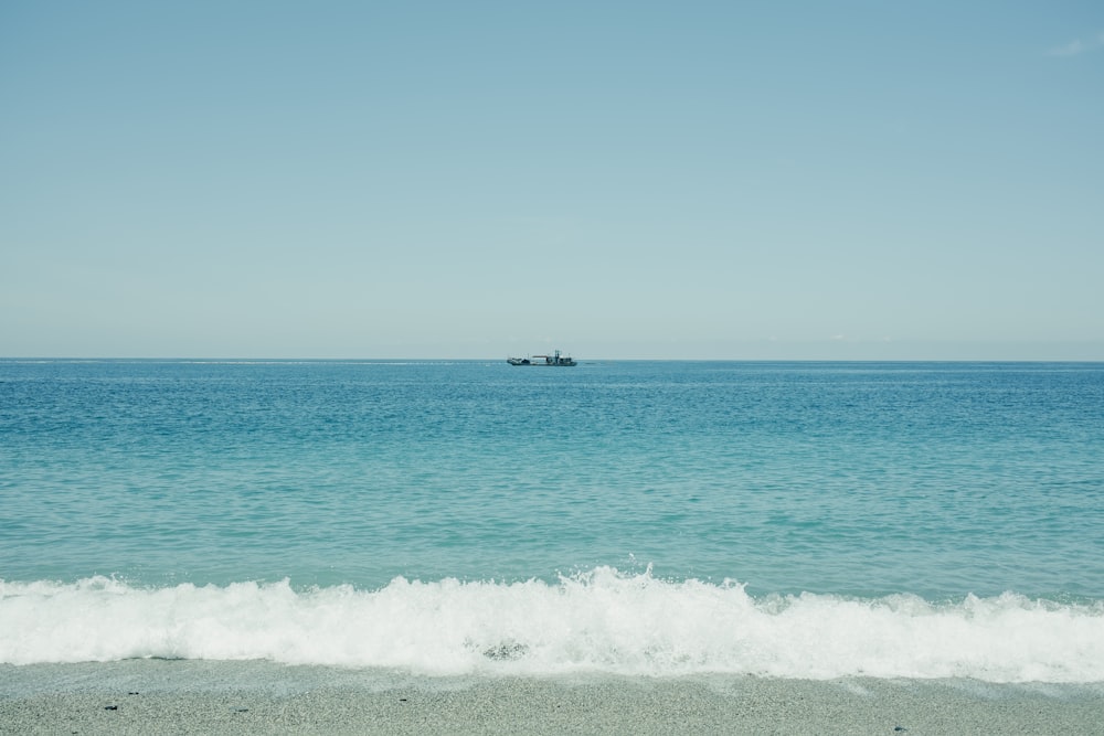 a boat out in the ocean on a sunny day