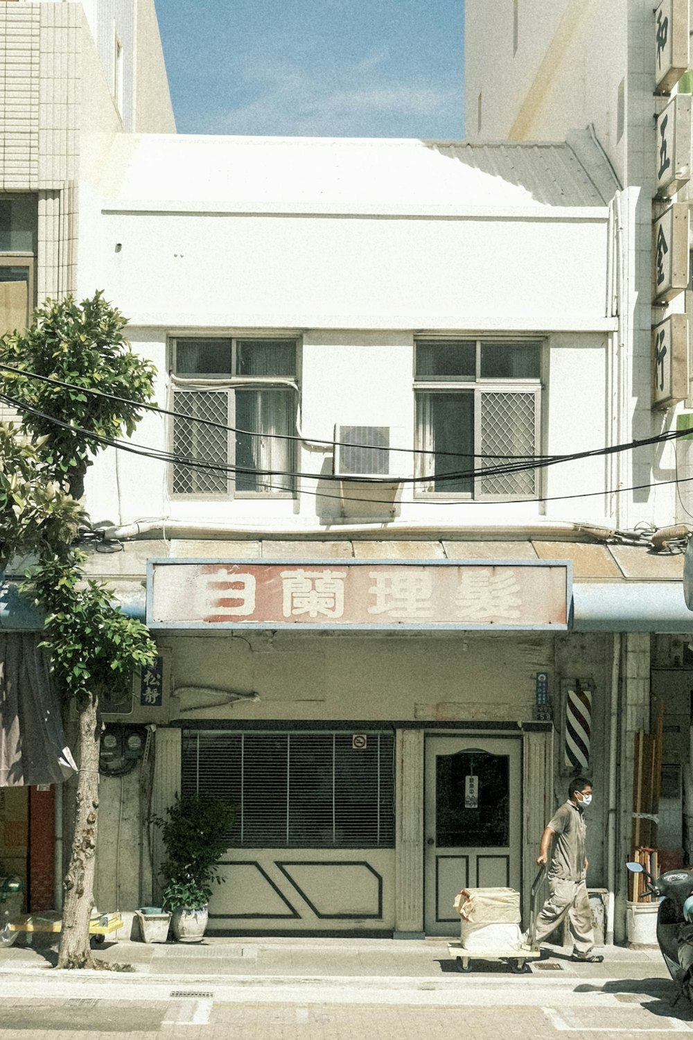 a man walking across a street next to a tall building