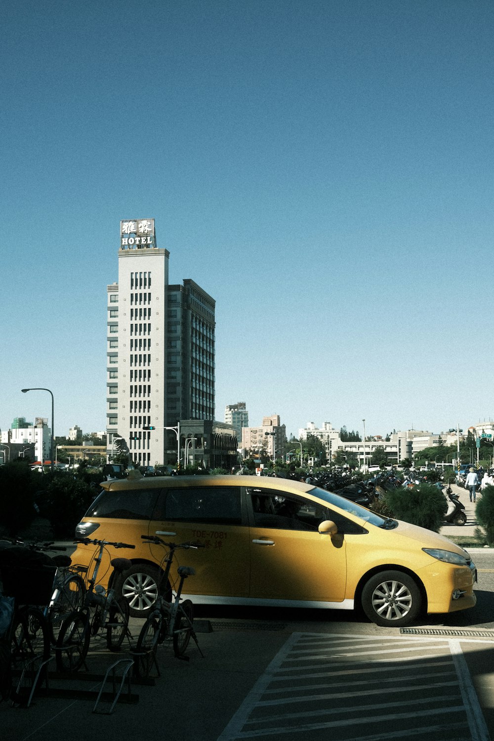 a yellow car parked in front of a tall building