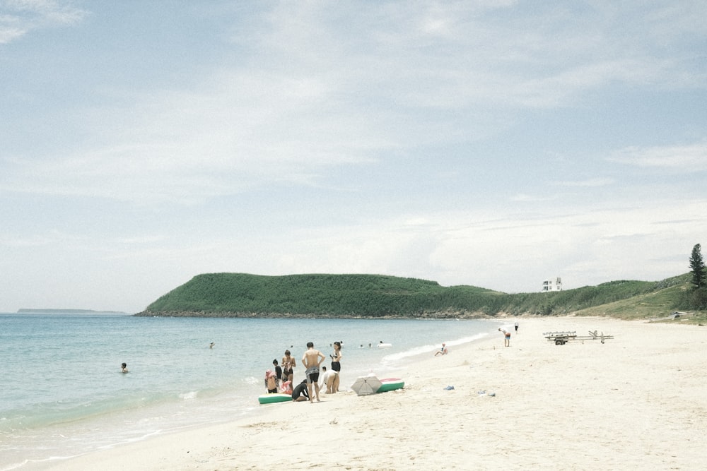 a group of people standing on top of a sandy beach