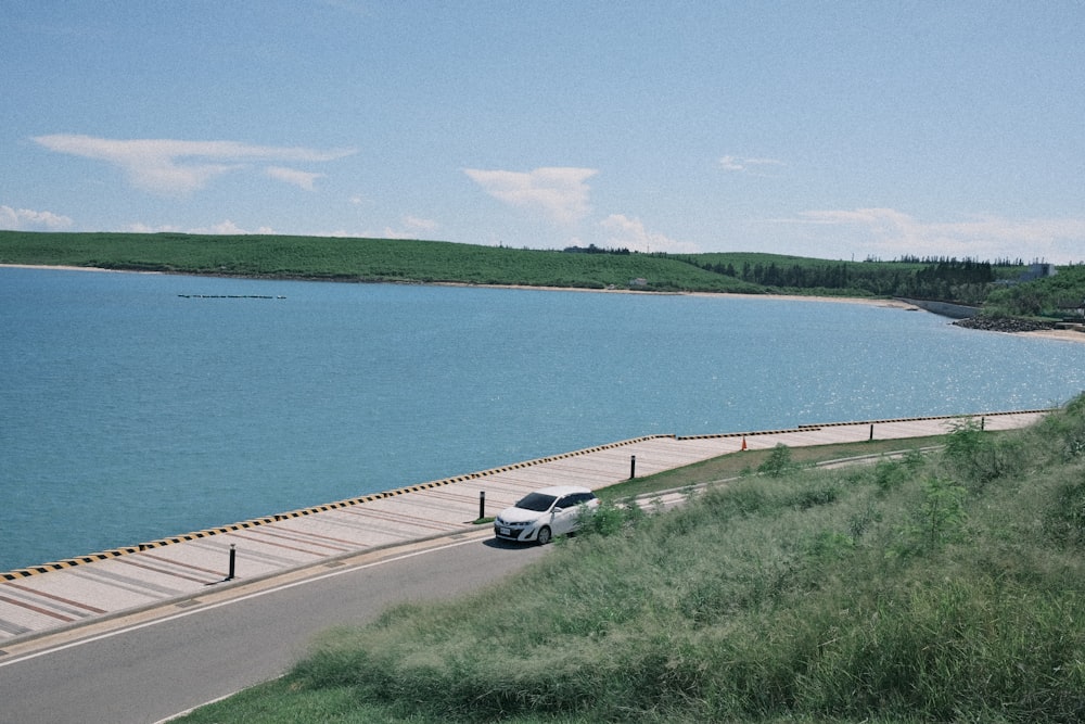 a van is parked on the side of the road near the water