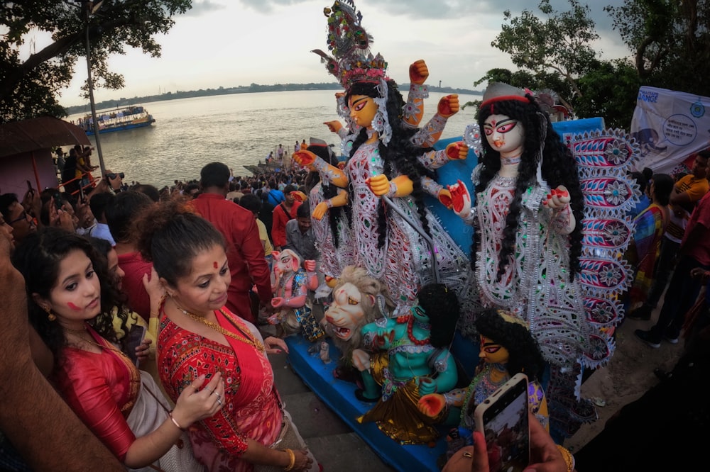 a group of people standing around a float with dolls on it