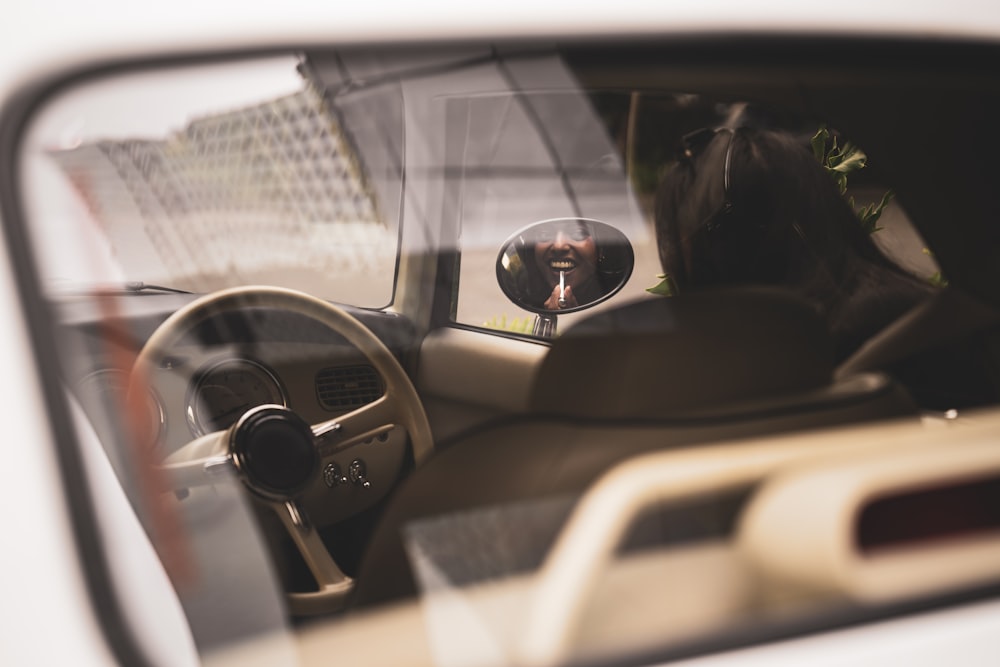 a reflection of a person in a car's side view mirror