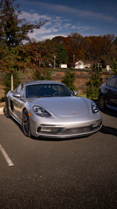 A sleek car parked in front of a modern Nevada home under a bright blue sky.
