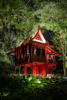 a red house in the middle of a forest