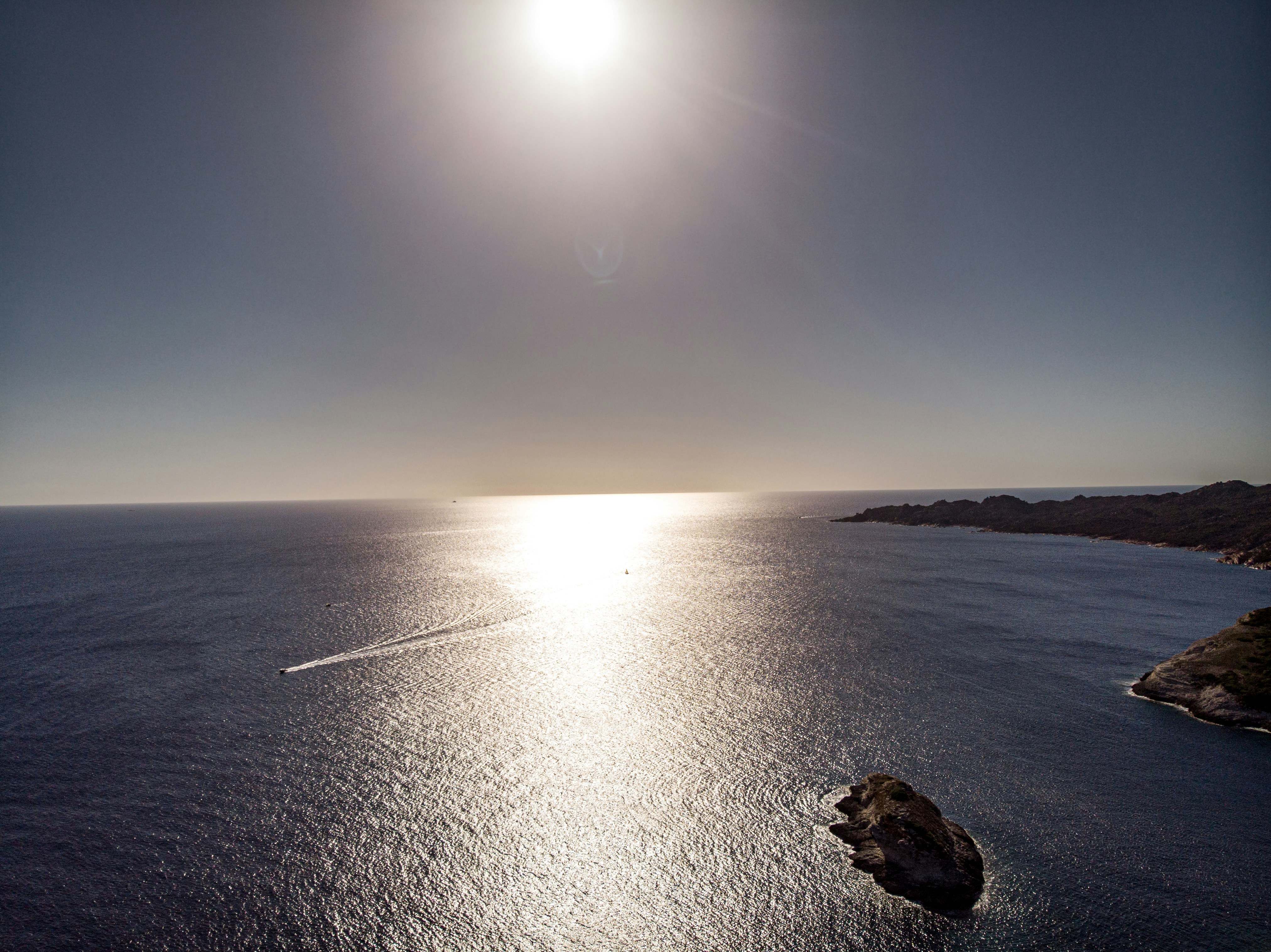 the sun is shining over a body of water