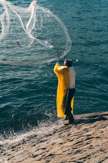 a man standing on top of a beach next to a body of water