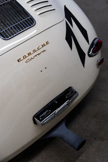 Side profile of a sleek restored Porsche 911 with metallic gray paint and gold accents.
