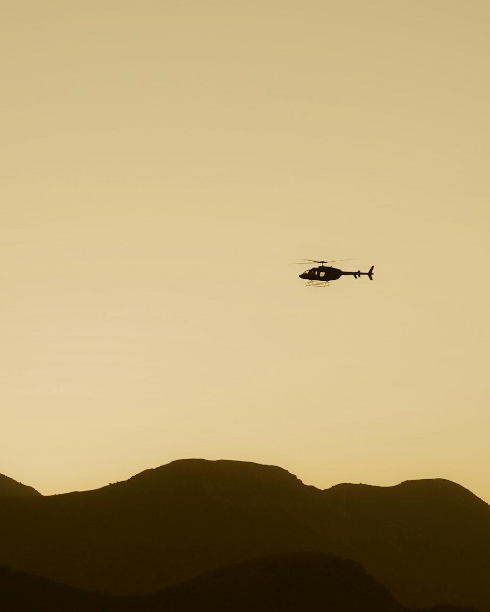 a helicopter is flying over a mountain range