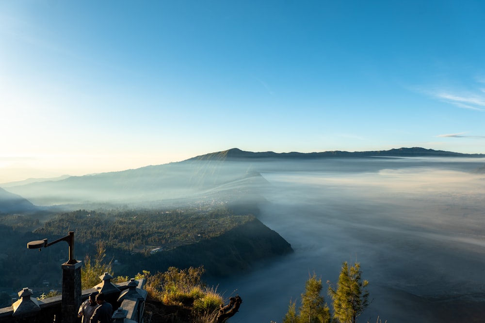 a view of a foggy valley with a mountain in the distance