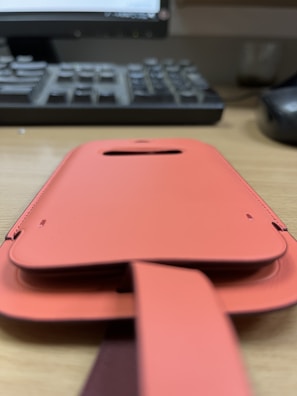 A stylish black and orange protective case for the Pro TV Box, resting on a wooden table.