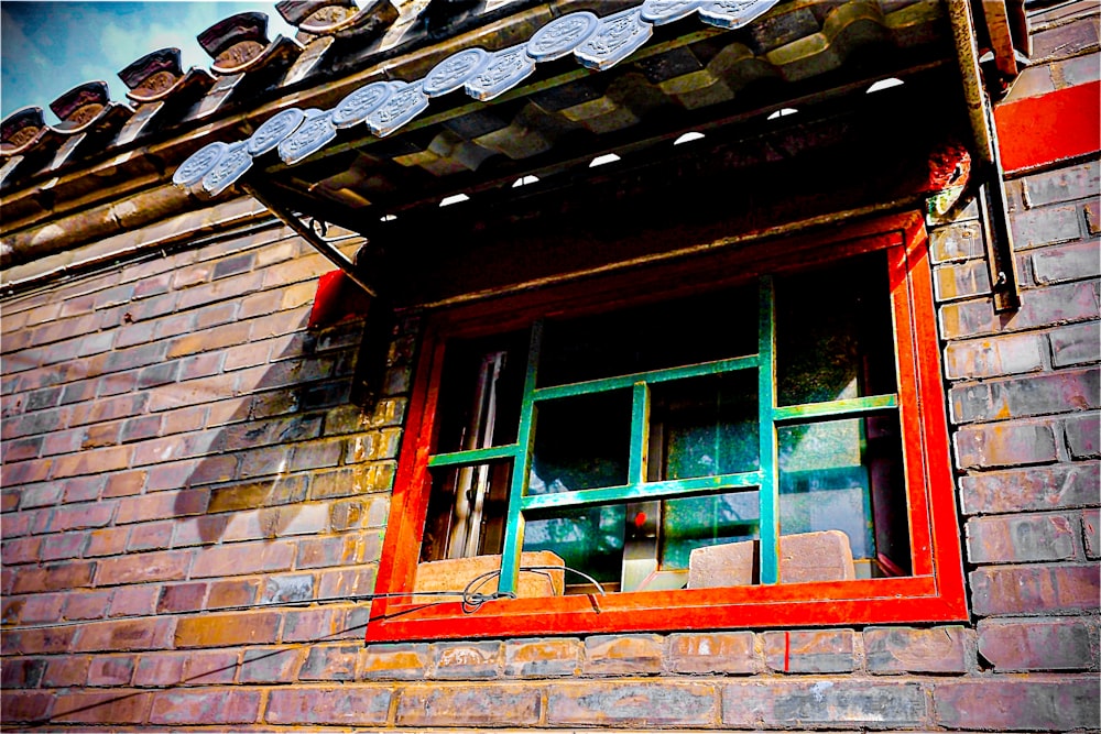 a red brick building with a green window