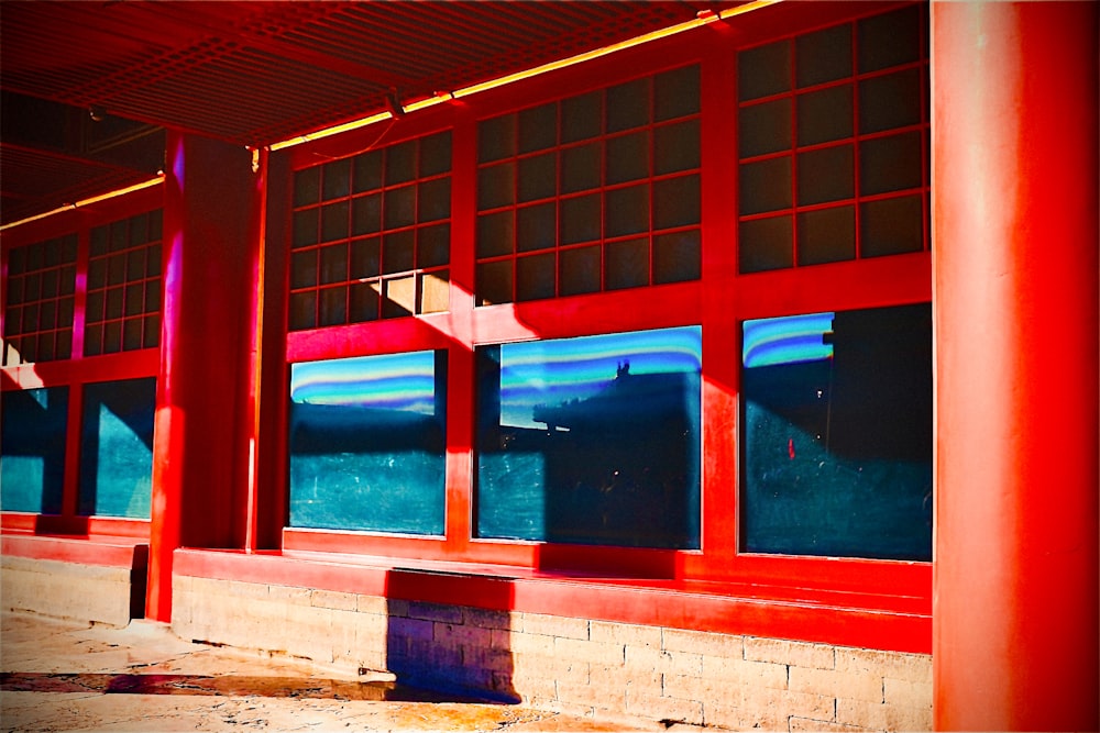 a red building with many windows and a bench in front of it