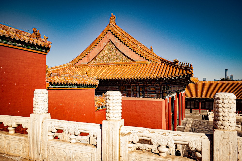 a building with a red roof and a white fence