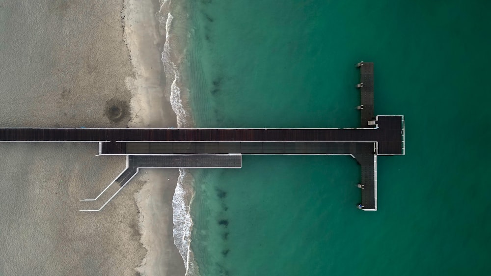 an aerial view of a pier on a beach