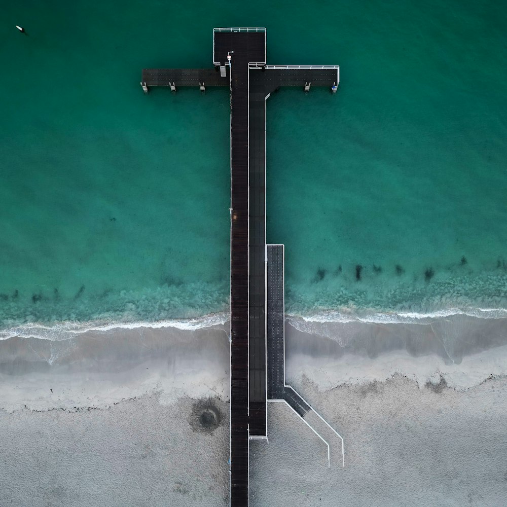an aerial view of a pier on the beach