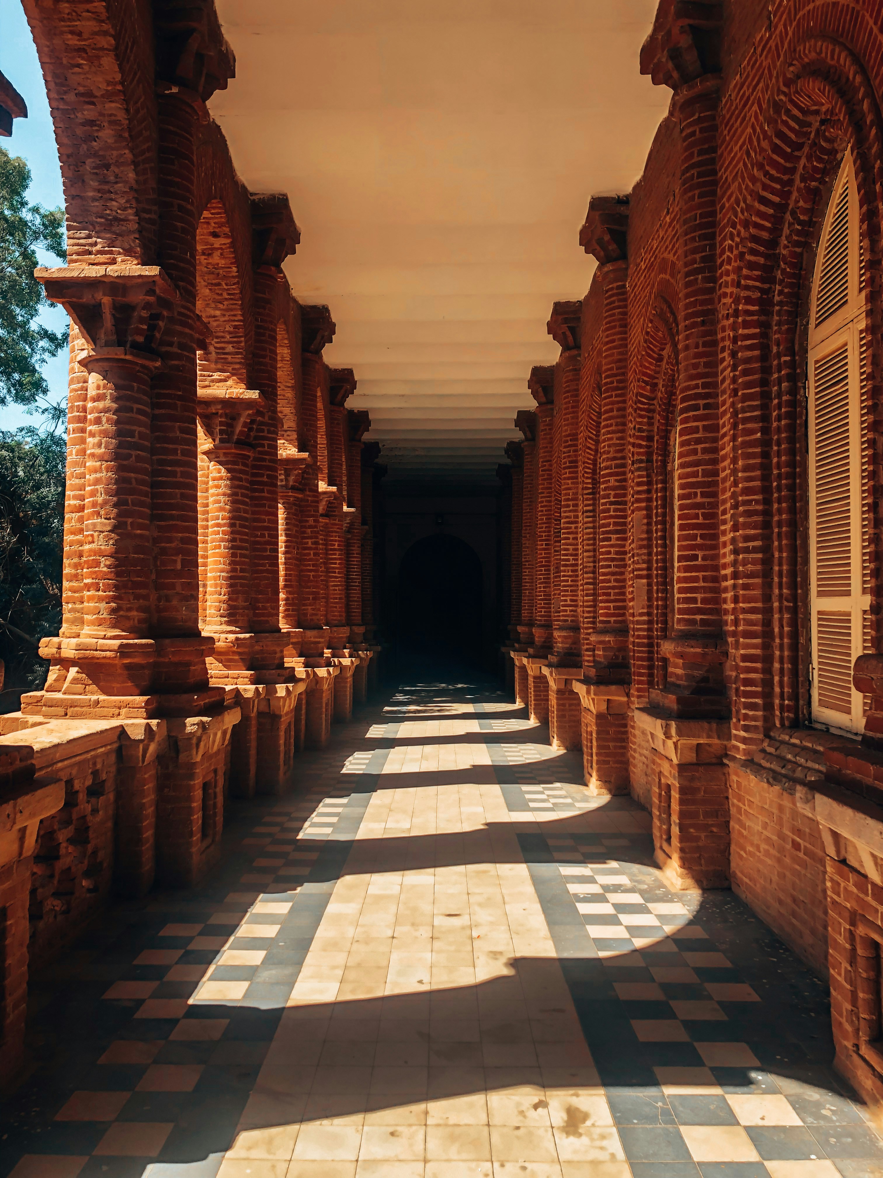 a long hallway lined with brick pillars and windows