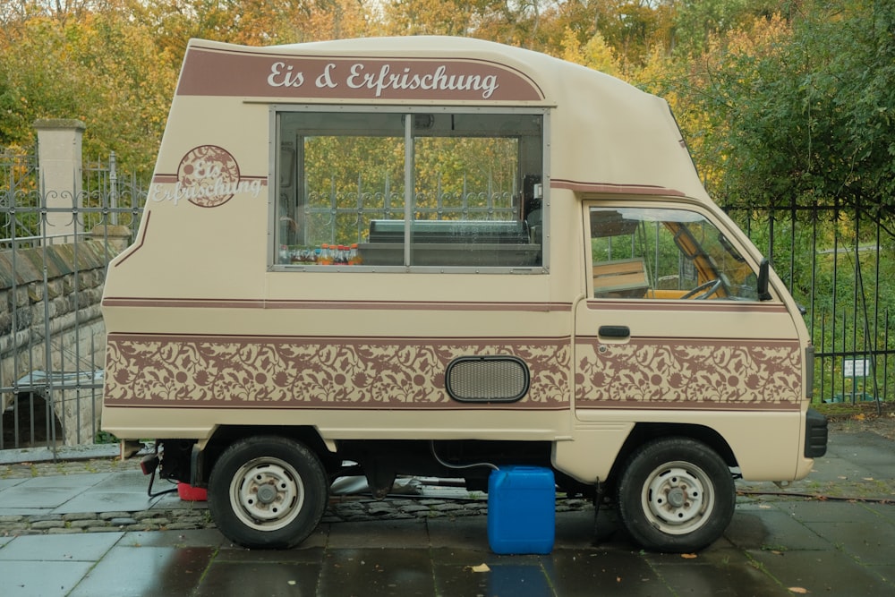 a small food truck is parked on the side of the road