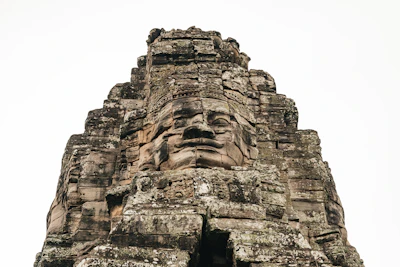 Close-up of one of Bayon temple's giant carved stone faces (via Unsplash)
