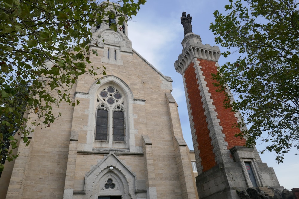 a tall church with a clock tower next to a tree