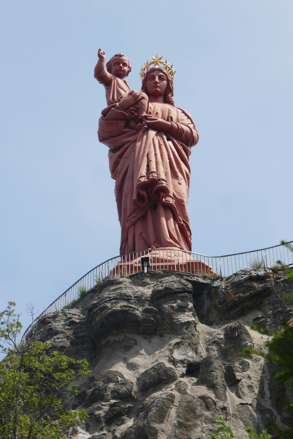 a statue of a woman with a crown on top of a hill