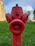 Technician inspecting a fire hydrant system on a sunny day at a commercial building.