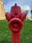 Technician inspecting a fire hydrant system on a sunny day at a commercial building.