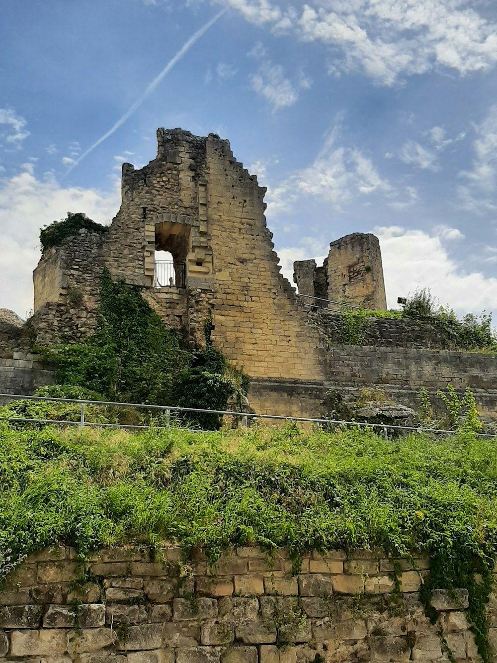 a stone castle with a fence surrounding it