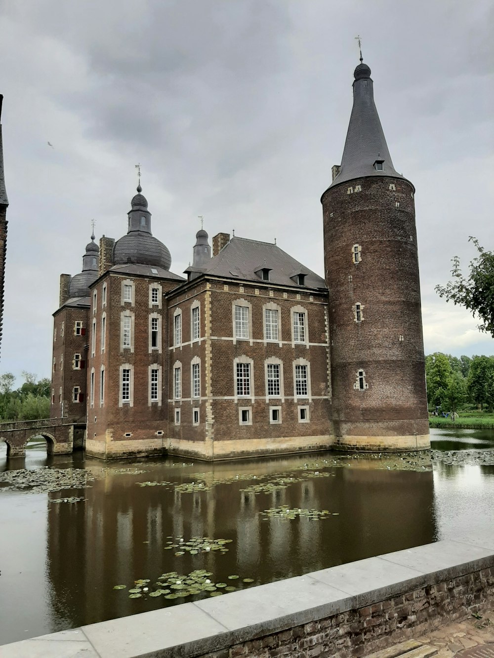 un grand bâtiment en brique situé au-dessus d’un lac