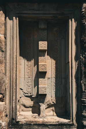 Intricate stone carvings on a temple wall bathed in warm afternoon sun.