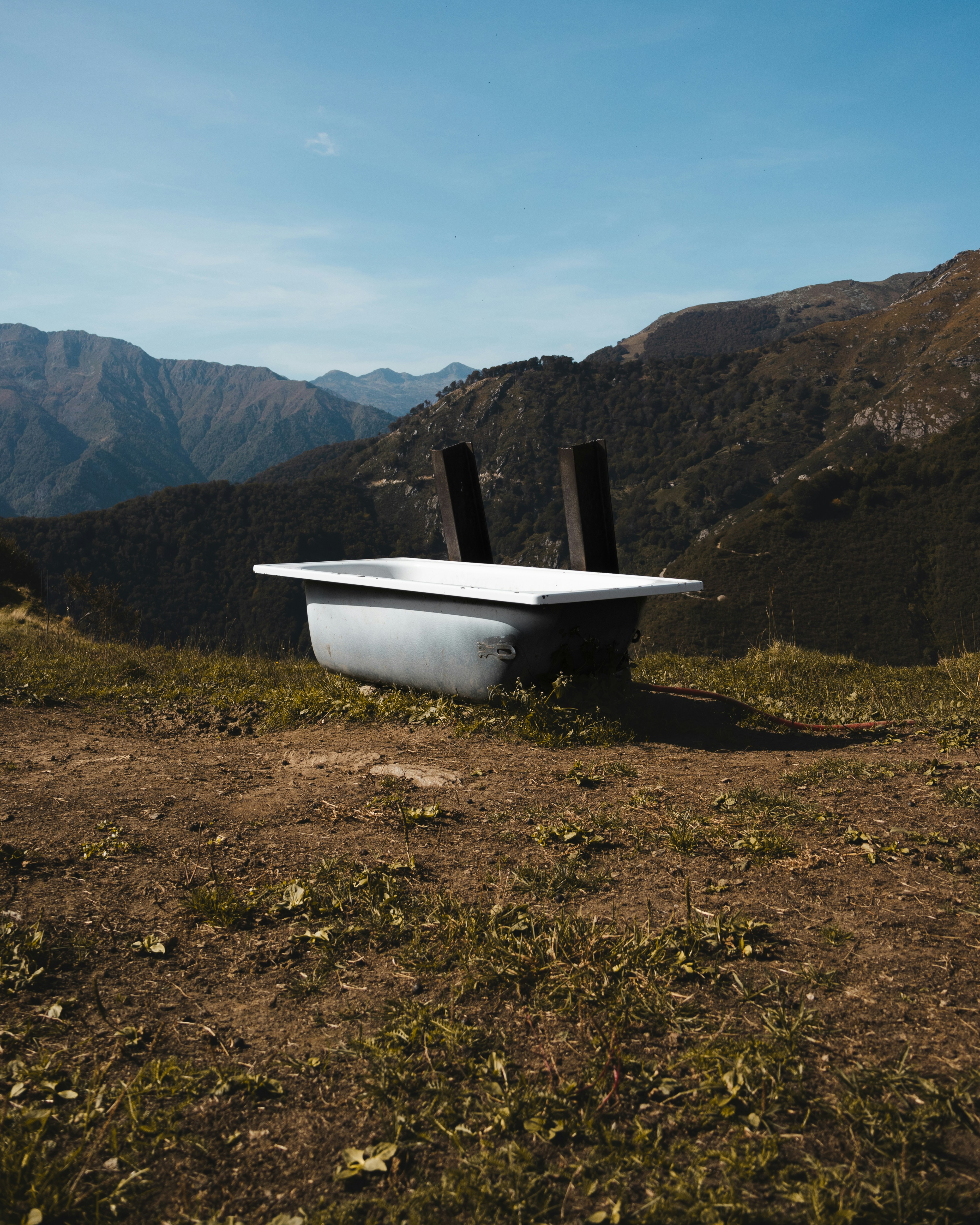 a bath tub sitting on top of a lush green hillside