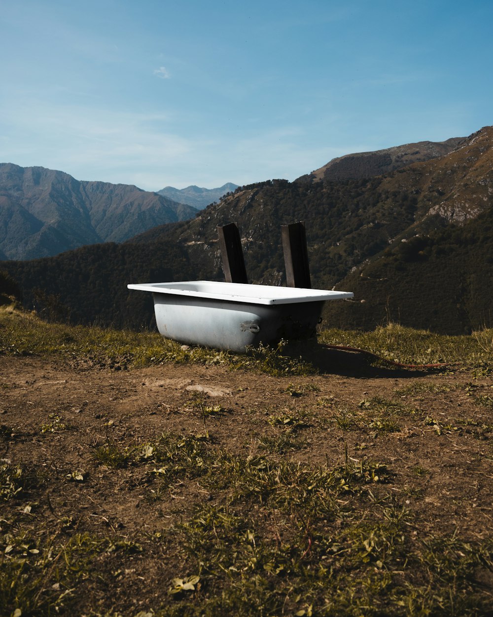 a bath tub sitting on top of a lush green hillside