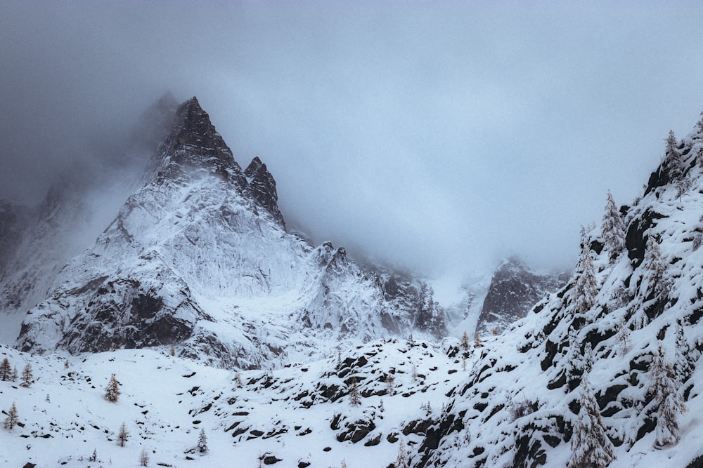 a mountain covered in snow with a cloudy sky