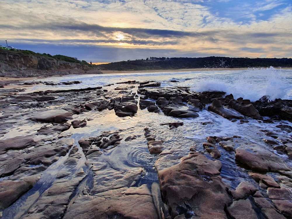 a rocky beach with waves crashing on the rocks