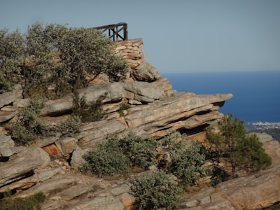 a rocky cliff with a small structure on top of it