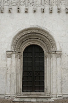 Sturdy oak door framed by a classic stone archway.